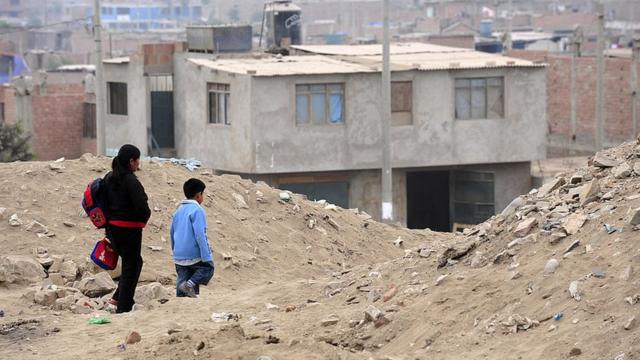 Niño caminando al colegio en una zona pobre de Lima.