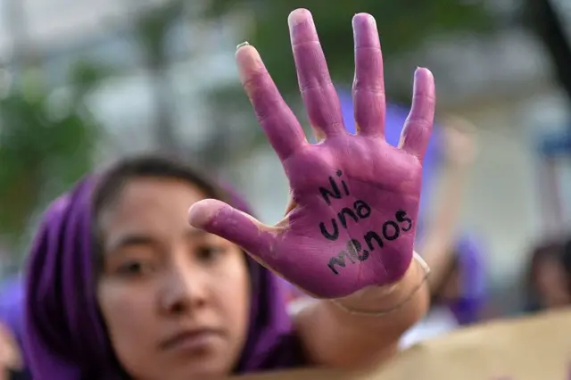 Mujer con la mano pintada en protesta por los feminicidios en México.
