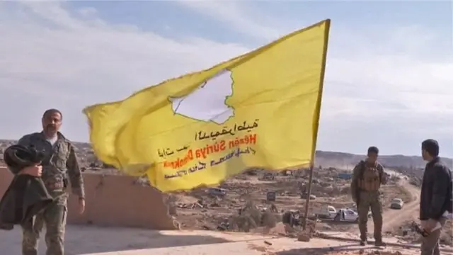 ਕੁਰਦ ਟੈਲੀਵੀਜ਼ਨ ਵੱਲੋਂ ਦਿਖਾਈ ਜਾ ਰਹੀ ਇੱਕ ਤਸਵੀਰ ਵਿੱਚ ਸਾਂਝੀਆਂ ਫੌਜਾਂ ਨੂੰ ਆਈਐੱਸ ਤੋਂ ਕਬਜ਼ੇ ਵਿੱਚ ਲਈ ਗਈ ਇੱਕ ਇਮਾਰਤ ਤੇ ਪੀਲਾ ਝੰਡਾ ਝੁਲਾਉਂਦਿਆਂ ਦਿਖਾਇਆ ਗਿਆ ਹੈ।