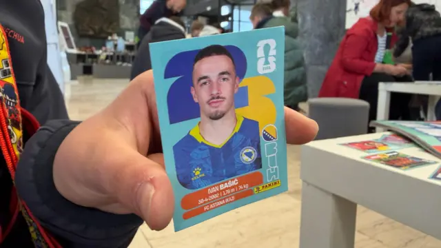 ruka drži sličicu bh. reprezentativca Ivana Bašića
