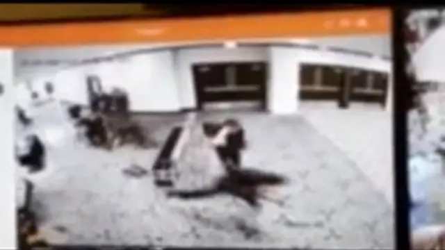 кадр записи с камер наблюдения в отеле, где мимо охраны быстро пробегает человек, изображение размыто 