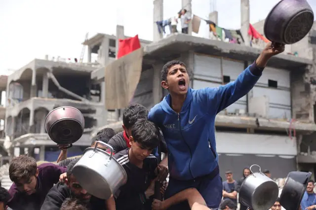 Niño pide comida con una olla. 