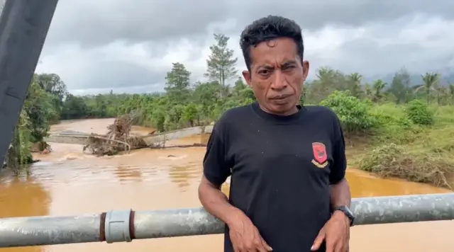 Pria dengan latar belakang banjir