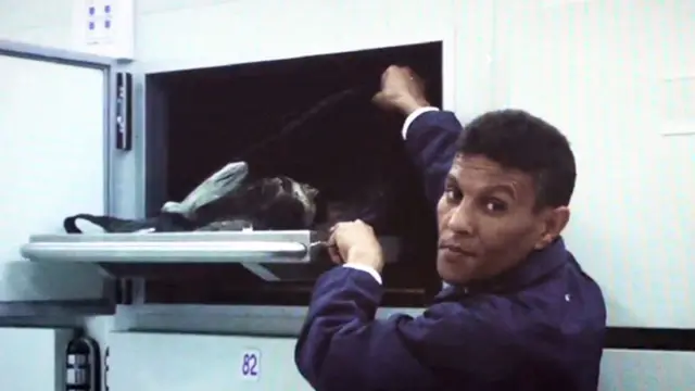 Službenik mrtvačnice pokazuje telo