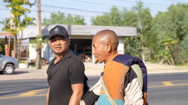 Sư Minh Tuệ bộ hành trên đất Thái Lan. Bên cạnh sư là ông Đoàn Văn Báu, cựu thượng tá an ninh, người tự xưng là trưởng đoàn do Công an Gia Lai cấp phép.