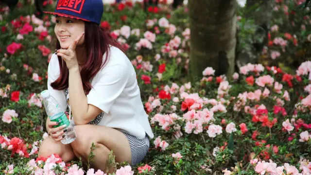 turista posando para foto em campo de flores 
