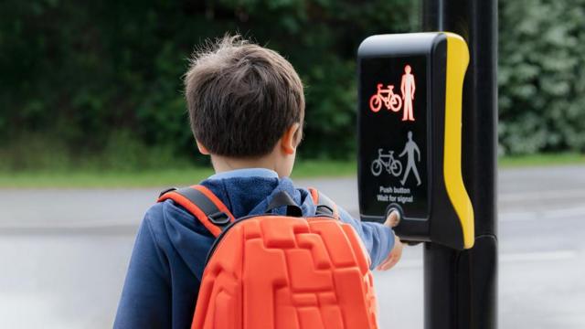 Meninopixbet futebol commochilapixbet futebol comcostas apertando botão para atravessar a rua 