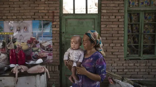 امرأة من أقليات الأيغور تحتفل بعيد القربان المعروف بعيد الأضحى عند المسلمين العرب