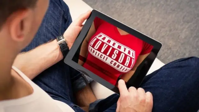 Hombre mirando pornografía en una tableta