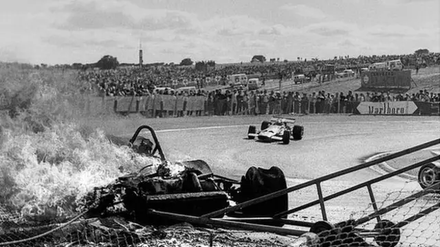 Jacky Ickx, Jochen Rindt, Ferrari 312B, Grand Prix of Spain, Circuito del Jarama, 19 April 1970. Jochen Rindt goes by the burning Ferrari of Jacky Ickx following the first lap accident. (Photo by Bernard Cahier/Getty Images)