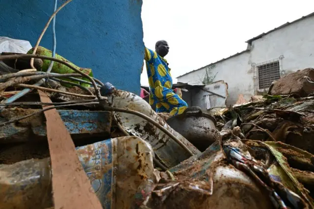 The owner inspects the damage at his house in Mossikro, Abidjan, after flooding caused by heavy rains, which left at least 4 people dead.