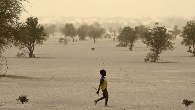 Un niño camina en una zona desértica en Mali.