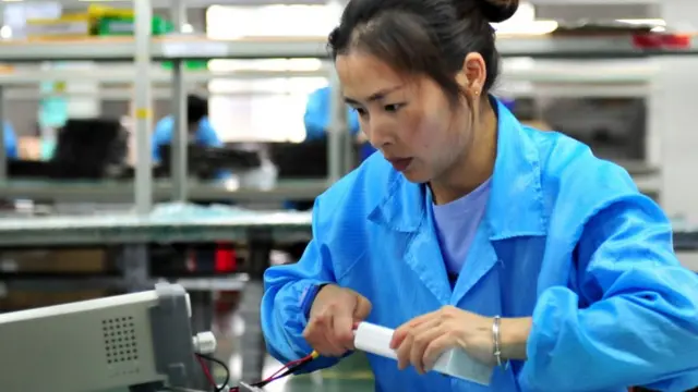 Operaria china con una batería