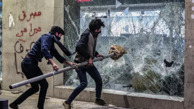 محتجون يحطمون واجهة أحد المصارف