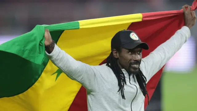 L'entraîneur principal du Sénégal, Aliou Cissé, brandit un drapeau sénégalais alors qu'il célèbre sa victoire après le match de football de la finale de la Coupe d'Afrique des Nations (CAN) 2021.