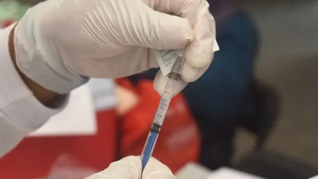 Le personnel médical préparant une dose de SinoVac.