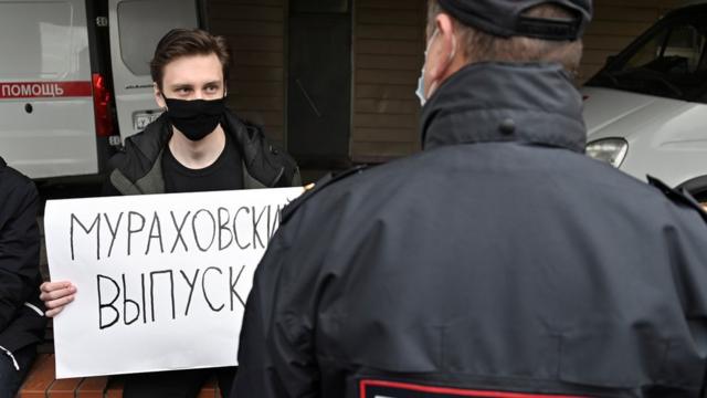 Мужчина у больницы в Омске, где лежал Навальный, с плакатом "Мураховский, выпускай"