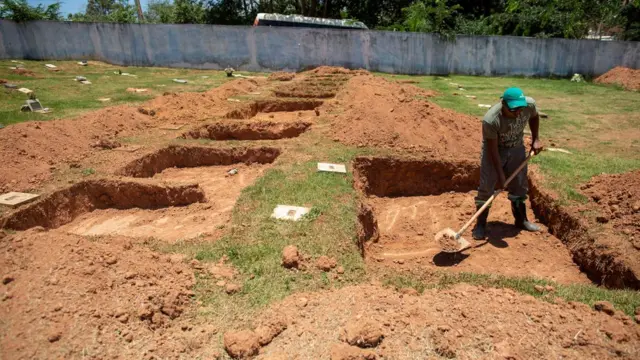 Homem abre covas no cemitério Parque das Rosas