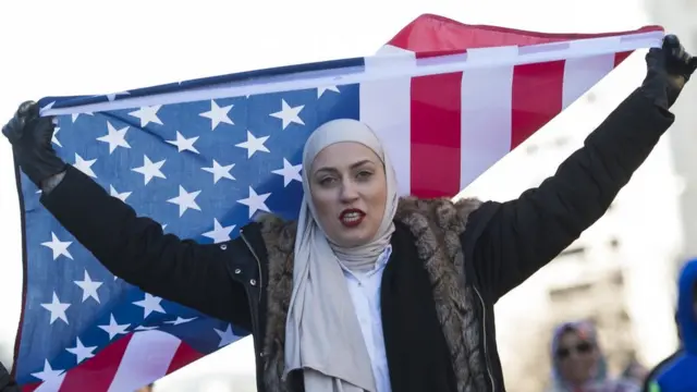 Una mujer con un velo y la bandera estadounidense protesta contra Donald Trump en Washington DC el 4 de febrero.