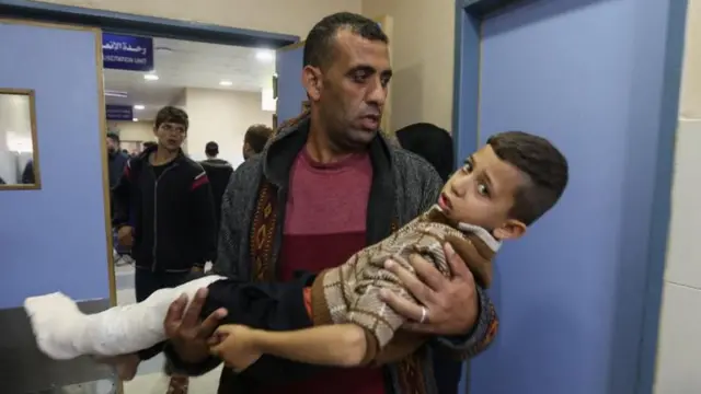 A Palestinian boy wounded in an Israeli strike is carried in Nasser hospital in Khan Younis in the southern Gaza Strip