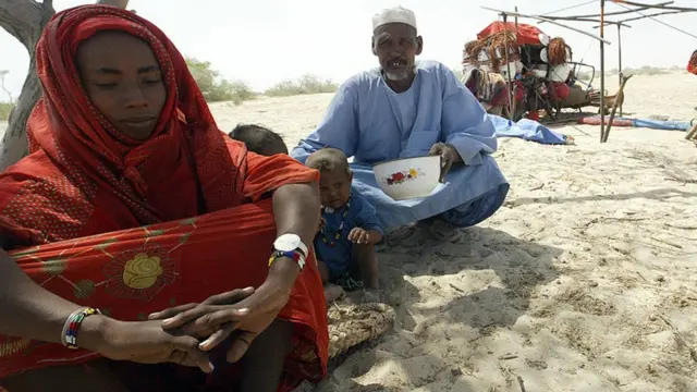 Le nomade Usman Habert tente de réconforter sa femme Fatima alors que le couple se prépare à quitter le camp du désert de Woudi après la menace d'expulsion par les autorités nigériennes
