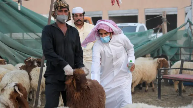 رجل يمسك بأضحية في الكويت
