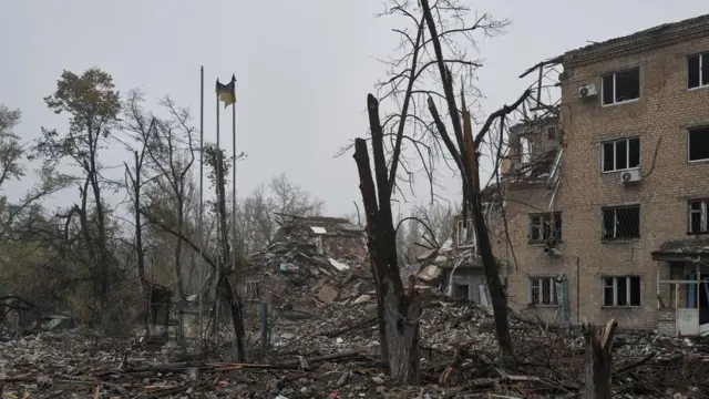 Ibiti byarashwe, ibendera rya Ukraine, n'ibisigazwa by'inyubako yashenywe mu mujyi wa Avdiivka, muri Ukraine 