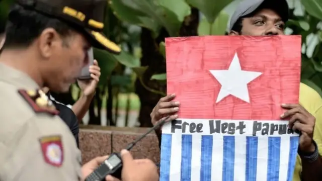 Seorang pengunjukrasa membawa simbol bendera Bintang Kejora menuntut pemisahan Papua dari Indonesia.