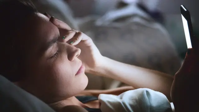 Mujer con móvil cama