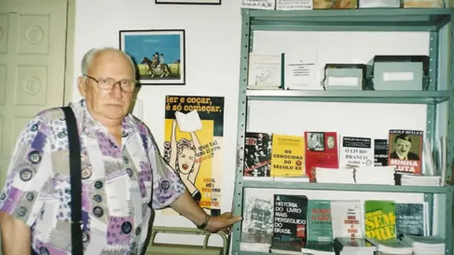 Siegfried Ellwanger, um idoso branco, calvo,campeonato brasileiro da série bóculos, ao ladocampeonato brasileiro da série bsua coleçãocampeonato brasileiro da série blivros