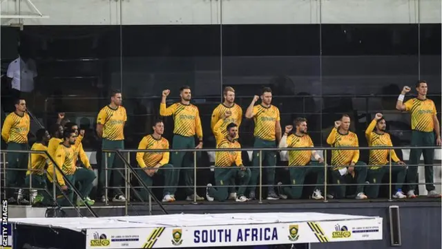 সবার বামে কুইন্টন ডি কক জুলাই মাসে ওয়েস্ট ইন্ডিজের বিপক্ষে সিরিজে ক্রিকেটারদের সংহতি প্রদর্শনের সময় দুই হাত পিছনে রেখে দাঁড়িয়েছিলেন।