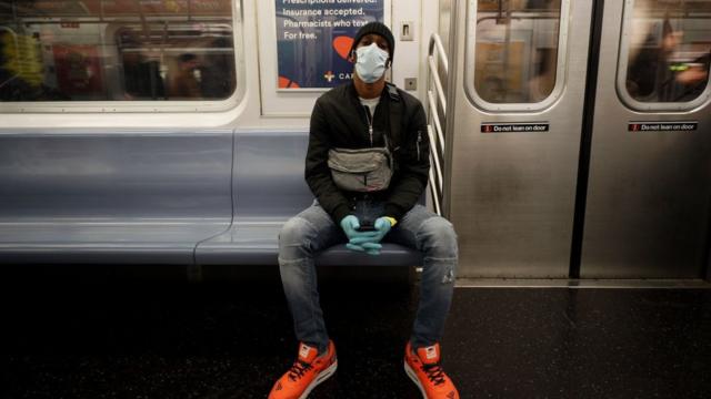 纽约地铁上戴上口罩和手套防疫的乘客