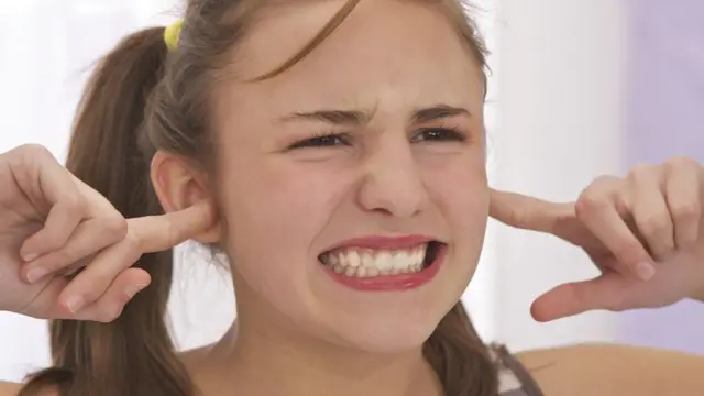 Mujer se tapa los oídos.