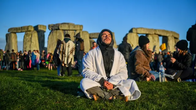Чоловік у позі йоги біля Стоунхенджу