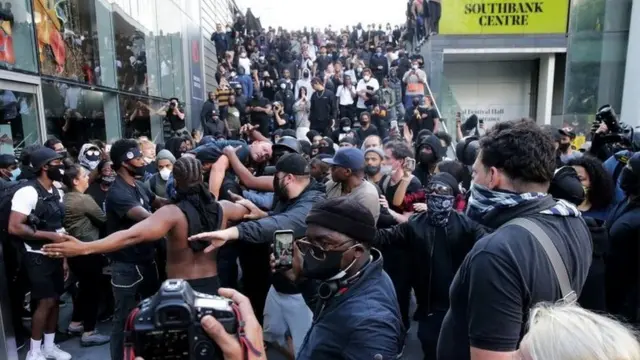 در نزدیکی پل واترلو تظاهرکنندگان یک مرد زخمی را روی دوش خود منتقل می‌کنند