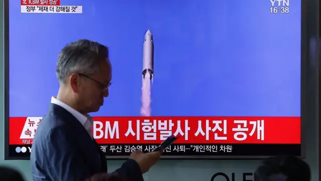 People watch a North Korea"s KRT television show a photo of North Korea"s test-launched first intercontinental ballistic missile released by Korean Central News Agency