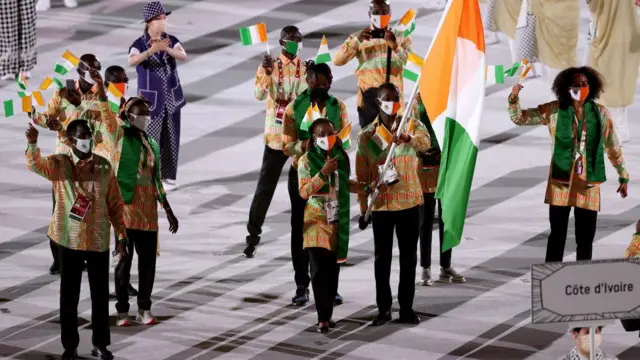 Flag bearers Marie-Josee Ta Lou and Cheick Sallah Cisse of Team Ivory Coast lead their team during the Opening Ceremony of the Tokyo 2020 Olympic Games