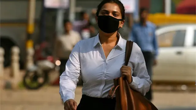 మాస్కు ధరించి వెళ్తున్న మహిళ