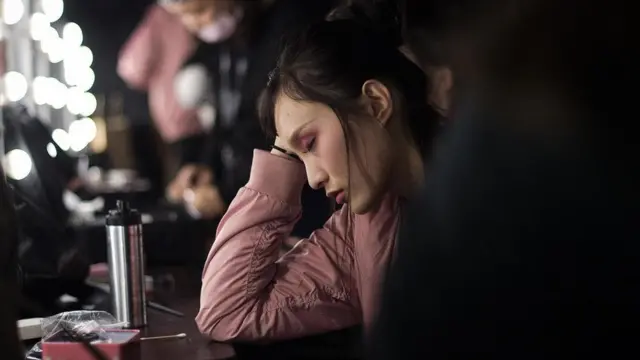 فتاة صينية تجلس وقد غلبها النعاس