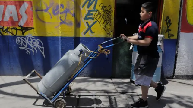 Niño cargando cilindro de gas en México