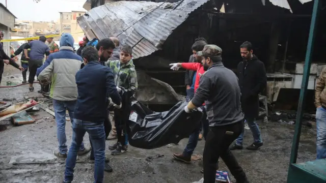 عراقيون يحملون جثة أحد الضحايا