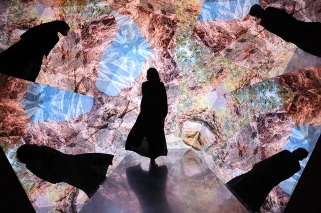 A woman looks at a video installation at a pavilion at the Expo 2020, in Dubai, on 1 December 2021