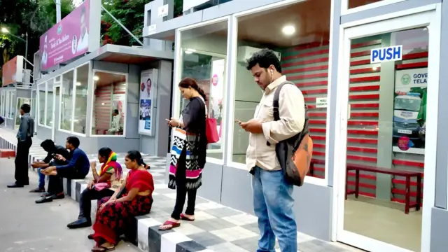 ఏసీ బస్‌స్టాప్ బయట వేచి ఉన్న ప్రయాణికులు