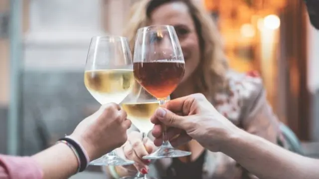 Des gens qui trinquent autour d'une table.