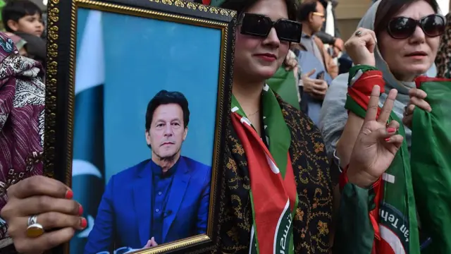 カーン氏の写真をもって集会に参加した、パキスタン正義運動（PTI）の支持者（カラチ、1月28日）