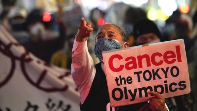 Homem segura cartaz com os dizeres 'Cancelem a Olimpíada de Tóquio'