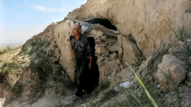 This photo taken on May 24, 2021 shows shepherd Zhu Keming, hailed as a hero in China for rescuing six ultramarathon runners when extreme weather hit the area leaving at least 20 dead, showing the cave dwelling where he sheltered the stricken athletes near the city of Baiyin, in China's northwestern Gansu province.