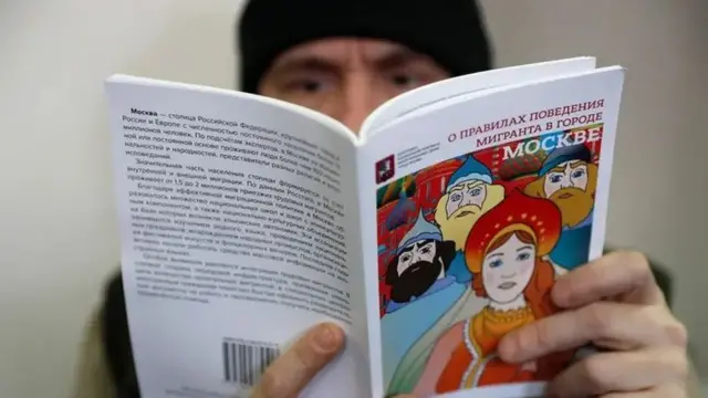 Мигрант вазифалари ёзилган китобни ўқиб турган инсон