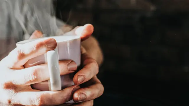 Una persona con una taza caliente.