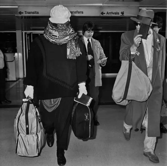 Cantor Boy George chega ao aeroportoroleta da sorteHeathrowroleta da sorte1985, disfarçando-se com um lenço